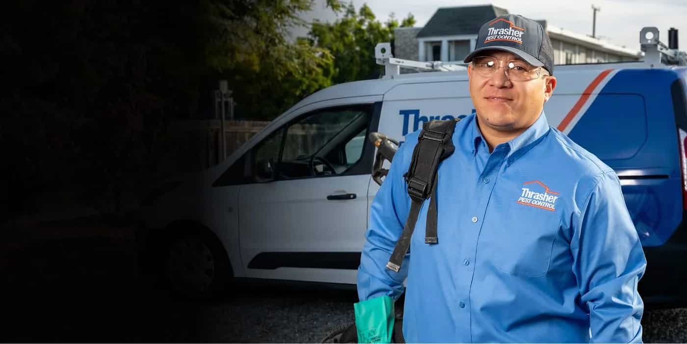 Thrasher Pest Control technician in front of a company service van